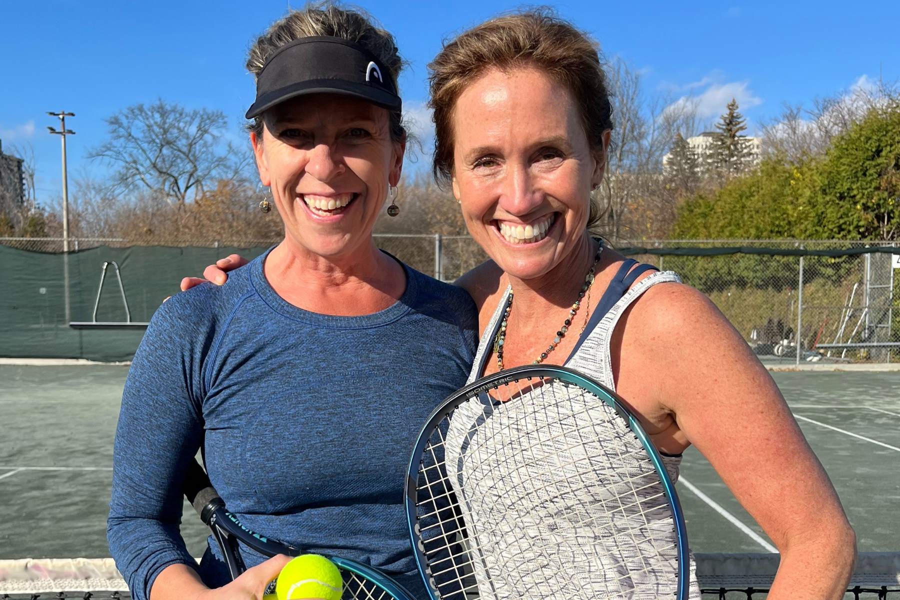 two women with summer tennis pass enjoying tennis on outdoor clay court in ottawa