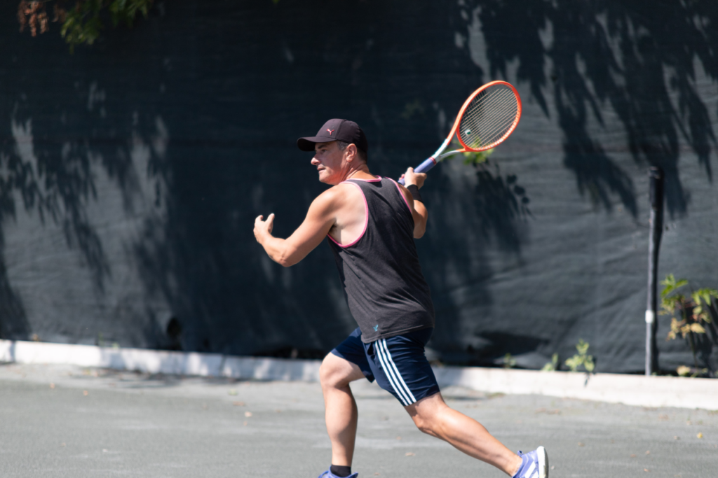 middle aged man with summer tennis pass enjoying tennis on outdoor clay court in ottawa